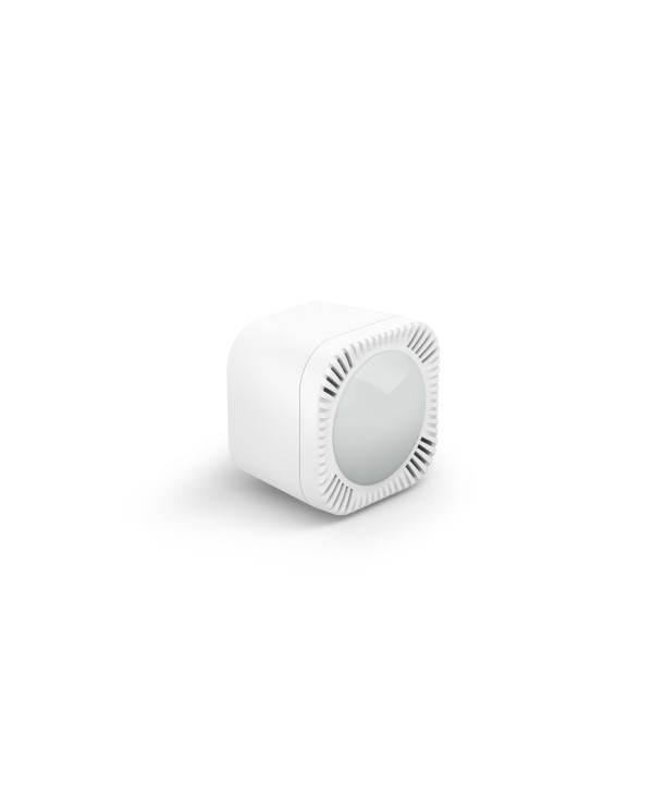 Mazs, balts sensors ar vairākām lēcām un LED indikatoru, novietots uz pelēka fona.